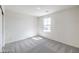 An empty bedroom with neutral carpet, a window and white walls, ready for customization at 1027 Gentle Swan St # 689, Henderson, NV 89011