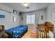 Cozy bedroom with a single bed, crib, wood floors, and bright curtains at 10373 Perfect Parsley St, Las Vegas, NV 89183