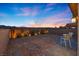 Charming backyard featuring desert landscaping, privacy wall, and patio with chairs at sunset at 10431 Seelos St, Las Vegas, NV 89178