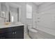 Bathroom with black cabinets, white countertop, and a shower-tub combo with white tile surround at 10431 Seelos St, Las Vegas, NV 89178