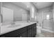 Bright bathroom with double sink vanity, large mirror, and glass enclosed shower at 10431 Seelos St, Las Vegas, NV 89178