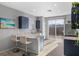 Bright kitchen featuring navy cabinets, granite countertops, and sliding glass doors at 10431 Seelos St, Las Vegas, NV 89178