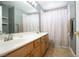 Bathroom featuring double sinks, a large mirror, and a shower behind a patterned curtain at 10902 Pentland Downs St, Las Vegas, NV 89141