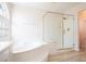 Clean, well-lit bathroom featuring a tub, a shower with glass door, and wood-look floor at 10902 Pentland Downs St, Las Vegas, NV 89141