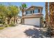 Exterior of a two-story home featuring desert landscaping and a two-car garage at 10902 Pentland Downs St, Las Vegas, NV 89141