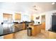 Open kitchen with stainless steel appliances, dark granite countertops, island, and wood cabinets at 10902 Pentland Downs St, Las Vegas, NV 89141