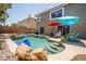 Inviting backyard pool area with colorful umbrellas and comfortable lounge chairs for relaxing poolside at 10902 Pentland Downs St, Las Vegas, NV 89141