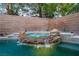 Backyard hot tub with natural rock waterfall feature and lush landscaping at 10902 Pentland Downs St, Las Vegas, NV 89141