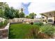 Landscaped backyard featuring artificial grass, a pool, and covered patio at 1413 Gentle Brook St, North Las Vegas, NV 89084
