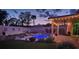 Beautiful backyard with an illuminated pool, covered patio, and serene ambience for evening enjoyment at 1413 Gentle Brook St, North Las Vegas, NV 89084