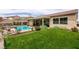 Lush backyard featuring a well-maintained lawn, covered patio, and a sparkling swimming pool for relaxation at 1413 Gentle Brook St, North Las Vegas, NV 89084