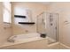 Well-lit bathroom featuring a tub and shower with glass doors at 1413 Gentle Brook St, North Las Vegas, NV 89084