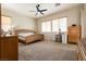 Spacious bedroom with carpet floors, a ceiling fan, and natural light from two windows at 1413 Gentle Brook St, North Las Vegas, NV 89084
