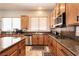 Bright kitchen featuring wood cabinets, granite countertops, stainless steel appliances, and tile flooring at 1413 Gentle Brook St, North Las Vegas, NV 89084