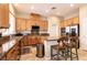 Well-lit kitchen with wood cabinetry, granite counters, stainless steel appliances, and eat-in island at 1413 Gentle Brook St, North Las Vegas, NV 89084