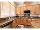 Spacious kitchen featuring granite countertops, wood cabinetry, and stainless steel appliances at 1413 Gentle Brook St, North Las Vegas, NV 89084