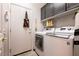 Functional laundry room with modern washer and dryer and upper cabinets at 1413 Gentle Brook St, North Las Vegas, NV 89084