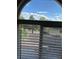 Backyard view through a window with blinds, showcasing the gravel landscape and block wall at 1511 Balsam Mist Ave, Las Vegas, NV 89183