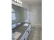 Bathroom featuring a dual sink vanity with granite countertop, a tub, and ample lighting at 1511 Balsam Mist Ave, Las Vegas, NV 89183