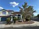 Charming two-story home featuring a tile roof, arched windows, and lush landscaping for a welcoming curb appeal at 1511 Balsam Mist Ave, Las Vegas, NV 89183