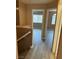 Hallway with neutral colors and hardwood floors leads to two bedrooms with windows at 1511 Balsam Mist Ave, Las Vegas, NV 89183