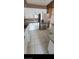 Modern kitchen featuring tiled floors, white cabinets, stainless steel appliances, and granite countertops at 1511 Balsam Mist Ave, Las Vegas, NV 89183