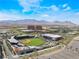 Aerial view shows the baseball field, nearby buildings, roads, and mountain views at 2152 Jasper Bluff St # 103, Las Vegas, NV 89117