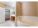 A full bathroom includes a soaking tub, tile flooring, and a walk-in closet at 2152 Jasper Bluff St # 103, Las Vegas, NV 89117