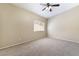 A neutral bedroom features plush carpet, ceiling fan, and natural light from the window at 2152 Jasper Bluff St # 103, Las Vegas, NV 89117