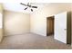 A well-lit bedroom has neutral carpet, light walls, a ceiling fan and an open door at 2152 Jasper Bluff St # 103, Las Vegas, NV 89117