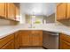 Well-lit kitchen with white countertops, wooden cabinets, and stainless steel dishwasher at 2152 Jasper Bluff St # 103, Las Vegas, NV 89117