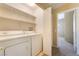 Functional laundry room with washer, dryer, and shelving for storage at 2152 Jasper Bluff St # 103, Las Vegas, NV 89117