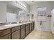 Bathroom featuring a double sink vanity with granite countertops and a large mirror at 2169 Rio Rancho Pointe Pl, Henderson, NV 89002