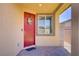 Covered front porch featuring a decorative red door and a window offering plenty of natural light at 2169 Rio Rancho Pointe Pl, Henderson, NV 89002
