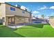 The backyard boasts a pool, an outdoor living area and low-maintenance artificial grass at 2402 El Cid Ct, Henderson, NV 89014