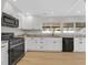 Modern kitchen featuring white cabinets, sleek black appliances, and granite countertops at 2402 El Cid Ct, Henderson, NV 89014