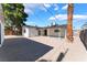 Spacious backyard with gravel, mature trees, and covered patio, perfect for outdoor living at 2481 San Marcos St, Las Vegas, NV 89115
