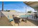Backyard with gravel landscaping, several chairs, a pool, and perimeter block fencing at 2496 Golfers St, Las Vegas, NV 89142