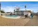 A refreshing pool is surrounded by a gravel backyard and a covered patio, perfect for outdoor enjoyment at 2496 Golfers St, Las Vegas, NV 89142