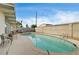 Backyard showcasing a large pool, desert landscaping, patio chairs, and perimeter fencing at 2496 Golfers St, Las Vegas, NV 89142