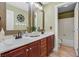 Bright bathroom with dual sinks, dark wood cabinets, and a separate room for the toilet and shower at 2555 Antique Blossom Ave, Henderson, NV 89052