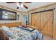 Rustic bedroom with wood trim, sliding barn doors, and a unique log bed frame at 2555 Antique Blossom Ave, Henderson, NV 89052
