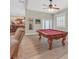 Spacious game room with a red felt billiard table, ceiling fan, and a view of the kitchen at 2555 Antique Blossom Ave, Henderson, NV 89052