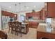 Charming kitchen features wood cabinets, stainless steel appliances, tile backsplash and island with seating at 2555 Antique Blossom Ave, Henderson, NV 89052