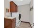Convenient laundry room featuring modern washer and dryer, storage cabinets, and a sink at 2555 Antique Blossom Ave, Henderson, NV 89052