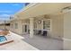 Relaxing covered patio with outdoor seating, ceiling fan, and views of the backyard oasis at 2555 Antique Blossom Ave, Henderson, NV 89052