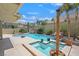 Inviting pool and spa with rock features and mature palm trees in a secluded backyard at 2555 Antique Blossom Ave, Henderson, NV 89052