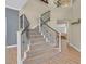 Staircase with carpeted steps, dark wrought iron spindles, and hardwood flooring in entry at 2555 Antique Blossom Ave, Henderson, NV 89052