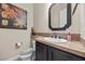 Powder room with decorative mirror, artwork and dark wood cabinets at 2577 Luberon Dr, Henderson, NV 89044