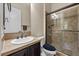 Well-lit bathroom with glass enclosed shower, vanity, and tile backsplash at 2577 Luberon Dr, Henderson, NV 89044